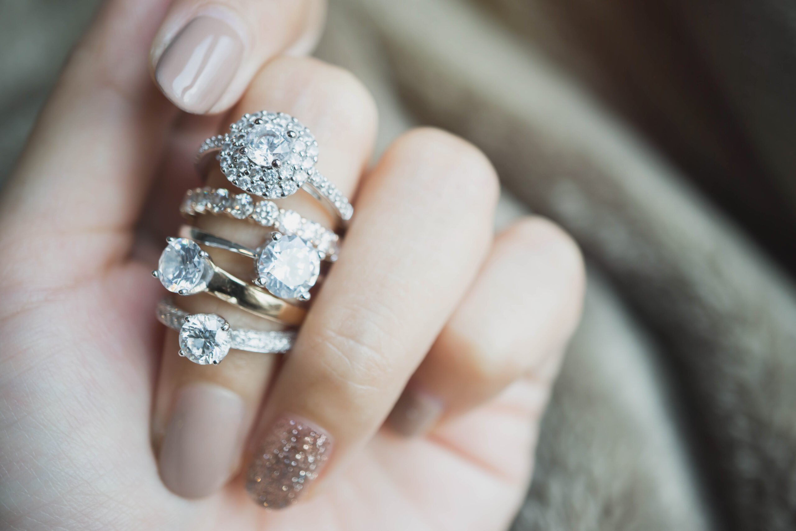 Close up of an elegant diamond ring on woman finger with white f